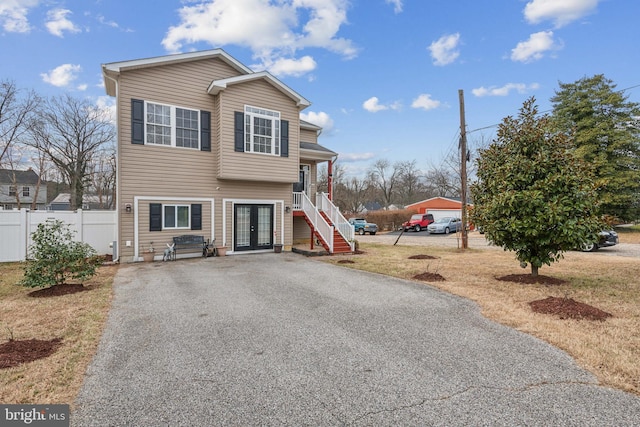 view of front of house with fence, stairway, and french doors