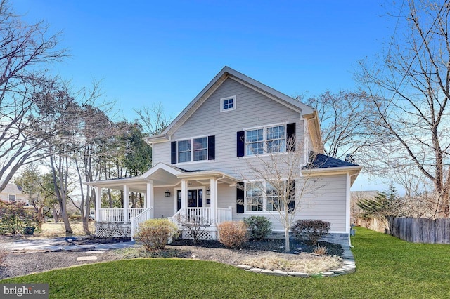 view of front facade featuring fence, driveway, a porch, a front lawn, and a carport