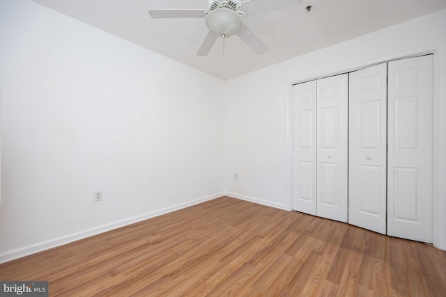 unfurnished bedroom with a closet, light wood-style flooring, baseboards, and ceiling fan