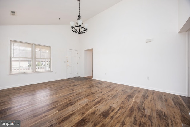 interior space with dark wood-type flooring, high vaulted ceiling, baseboards, and a chandelier