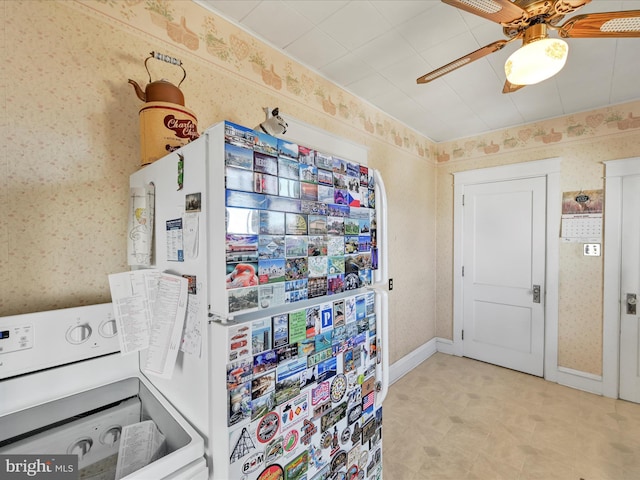 interior space featuring wallpapered walls, baseboards, and washer / dryer