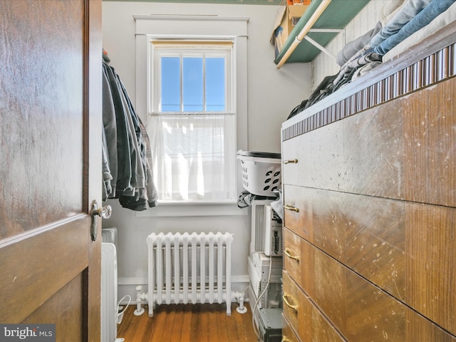 spacious closet with radiator heating unit and wood finished floors