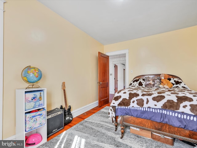 bedroom featuring baseboards and wood finished floors