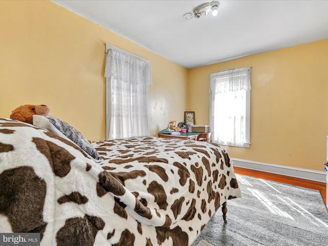 bedroom featuring baseboards and wood finished floors