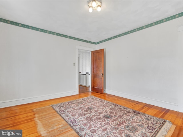 spare room featuring hardwood / wood-style floors and baseboards