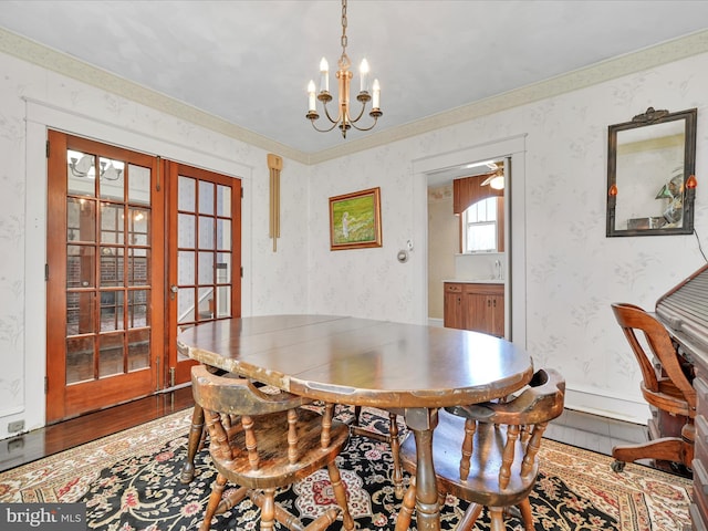 dining space with a notable chandelier, wood finished floors, baseboards, french doors, and wallpapered walls