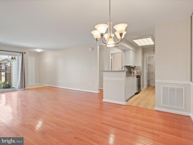 kitchen featuring tasteful backsplash, visible vents, light wood-style flooring, and an inviting chandelier