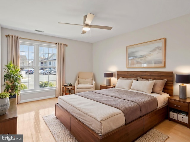 bedroom with light wood-style flooring, visible vents, and ceiling fan