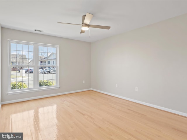 unfurnished room featuring baseboards, ceiling fan, visible vents, and light wood-style floors