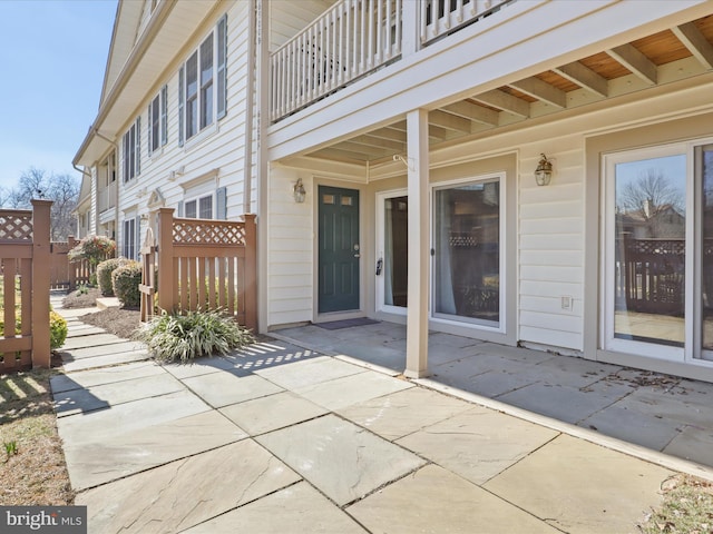 view of patio featuring fence and a balcony