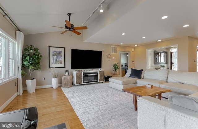 living area featuring baseboards, visible vents, vaulted ceiling, light wood-type flooring, and recessed lighting