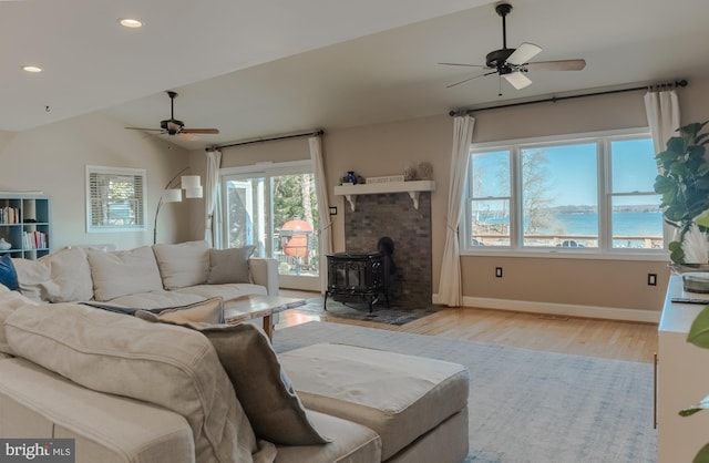 living room with a ceiling fan, lofted ceiling, recessed lighting, and wood finished floors