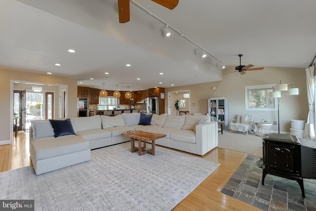 living room with lofted ceiling, ceiling fan, recessed lighting, and light wood-style floors