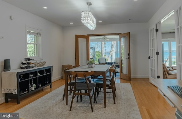 dining space with french doors, wood finished floors, and baseboards