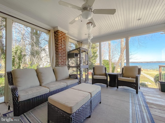 sunroom / solarium with a ceiling fan, a water view, and plenty of natural light