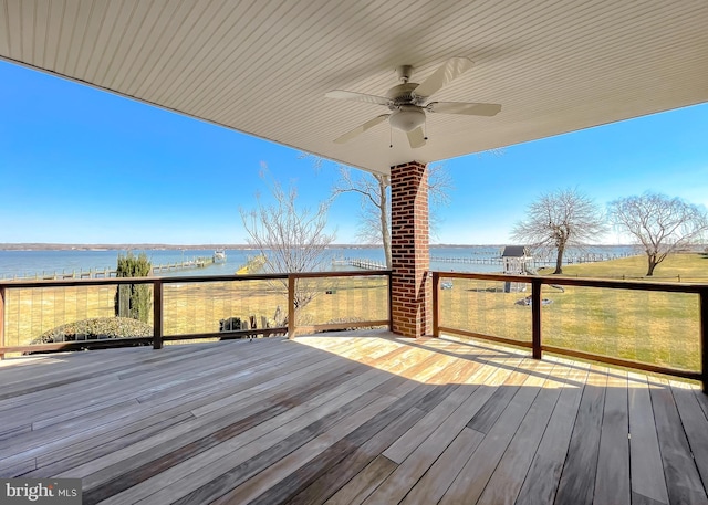 deck with a water view and ceiling fan