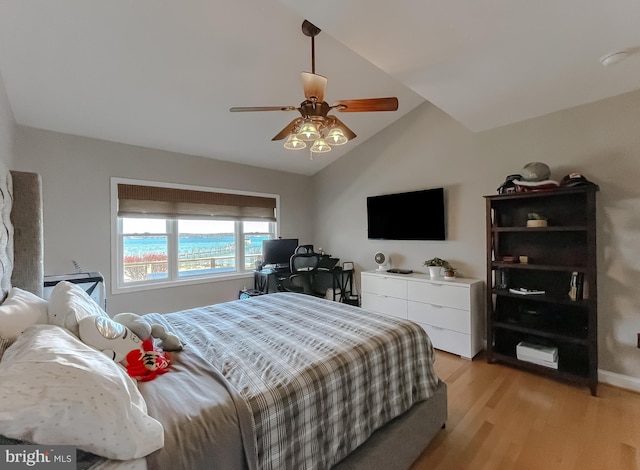 bedroom featuring light wood-style floors, vaulted ceiling, and ceiling fan