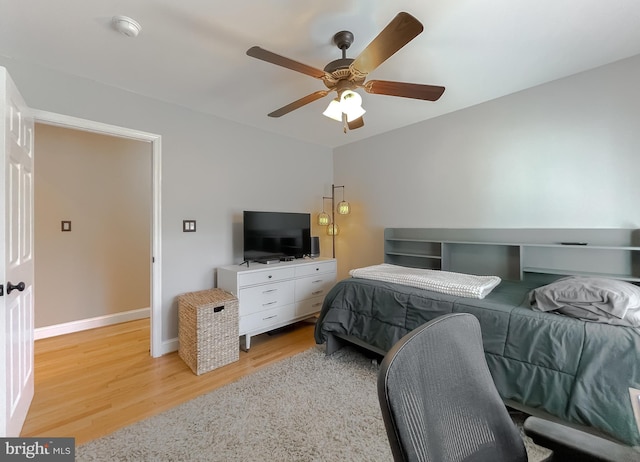 bedroom featuring light wood-style flooring, baseboards, and ceiling fan