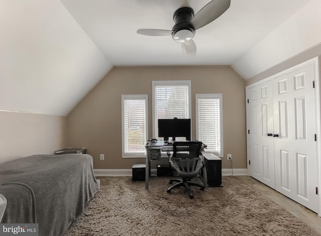 bedroom with a ceiling fan, lofted ceiling, baseboards, and carpet