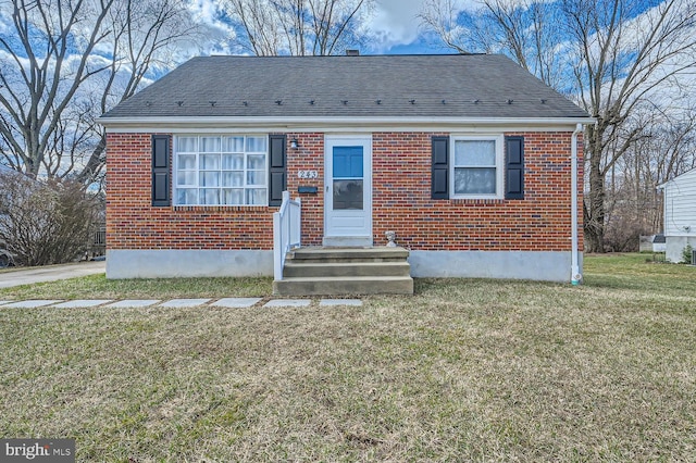 bungalow-style house featuring roof with shingles, brick siding, and a front lawn