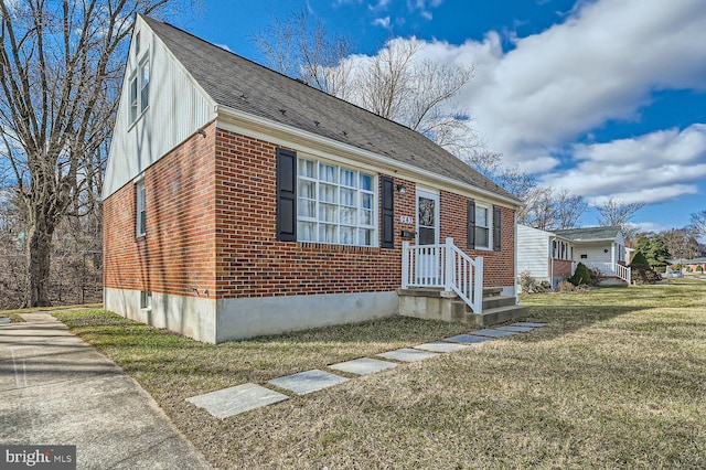 view of front of house with brick siding and a front lawn