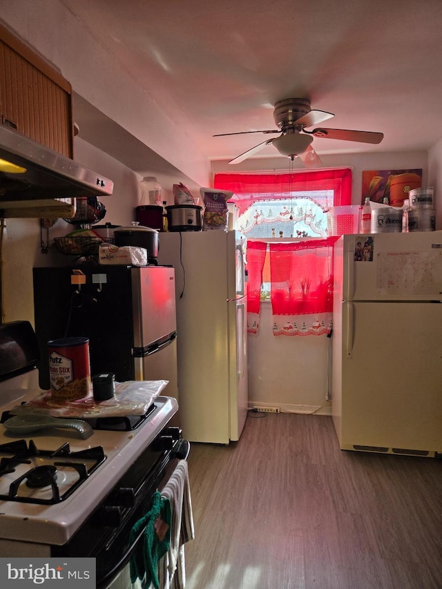 kitchen with gas stove, ceiling fan, wood finished floors, and freestanding refrigerator