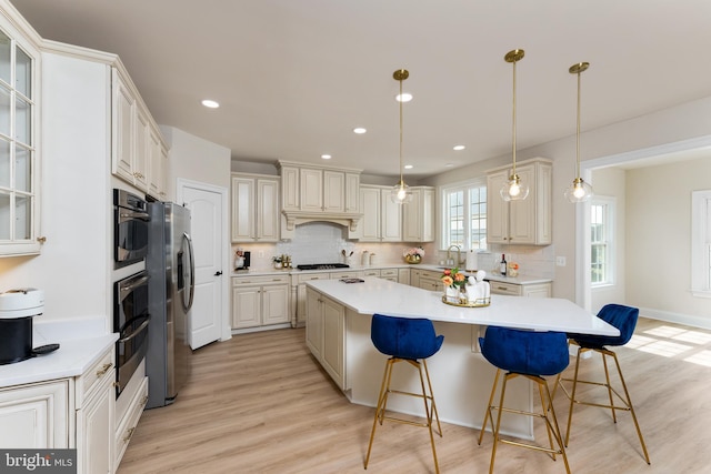 kitchen featuring a center island, a breakfast bar area, stainless steel appliances, and light countertops