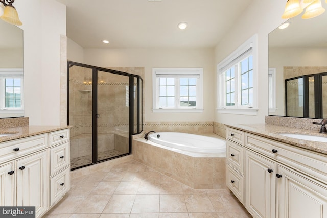 full bathroom featuring a shower stall, a garden tub, and a sink