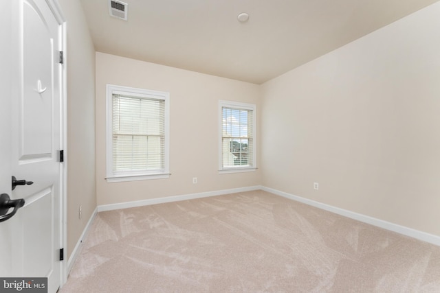 empty room with light carpet, visible vents, and baseboards