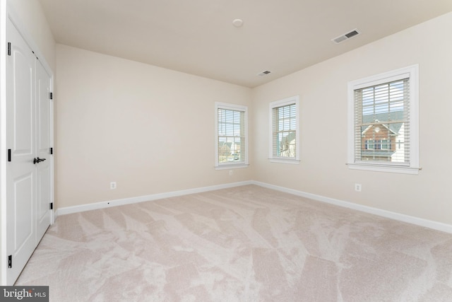 unfurnished bedroom with baseboards, visible vents, and light carpet