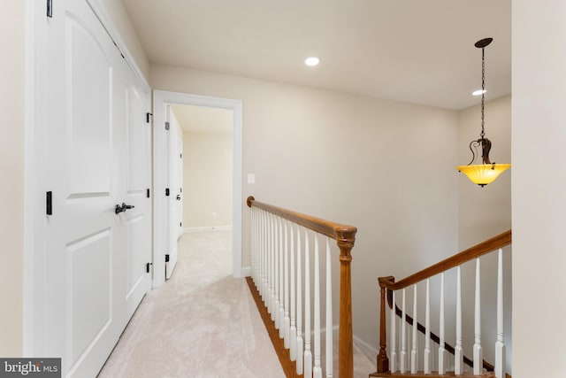 hall featuring an upstairs landing, carpet flooring, recessed lighting, and baseboards