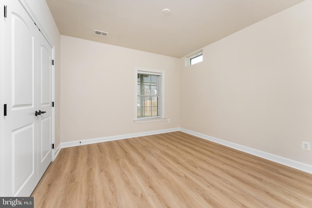 unfurnished bedroom with a closet, visible vents, light wood-type flooring, and baseboards