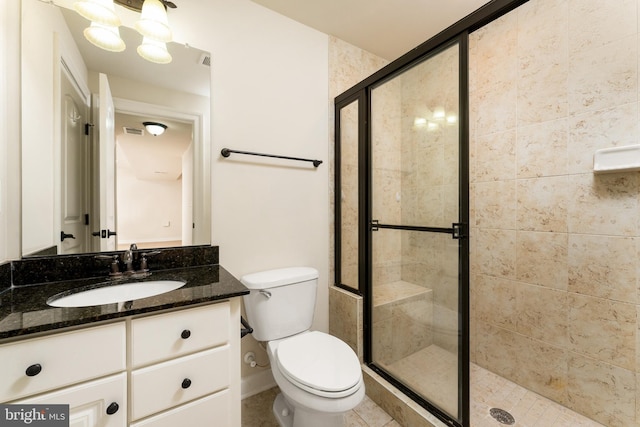 bathroom with visible vents, baseboards, toilet, a stall shower, and vanity