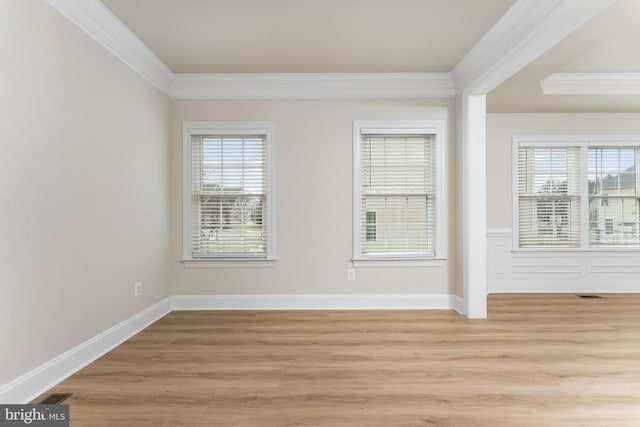 unfurnished room featuring light wood-type flooring, visible vents, and crown molding