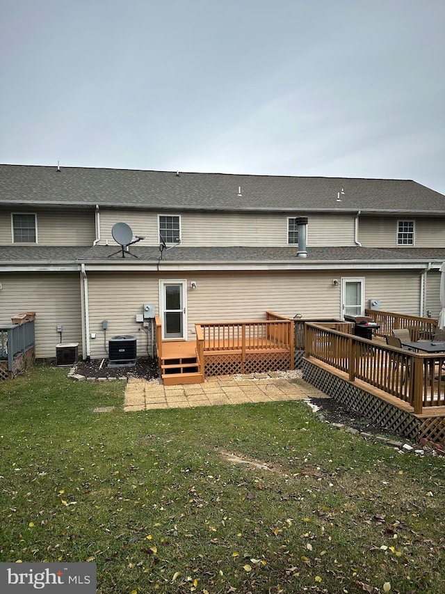 back of property with a yard, cooling unit, and a wooden deck