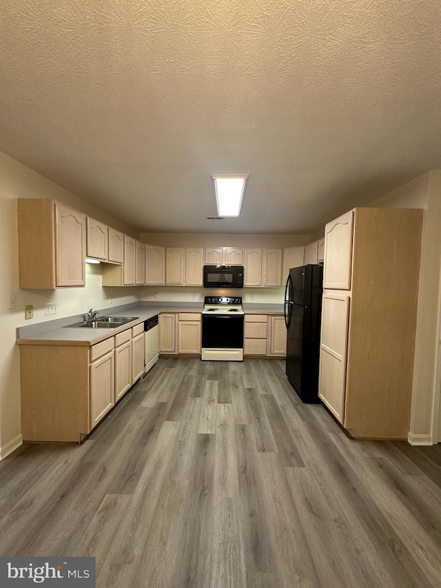 kitchen with light brown cabinetry, a sink, a textured ceiling, wood finished floors, and black appliances