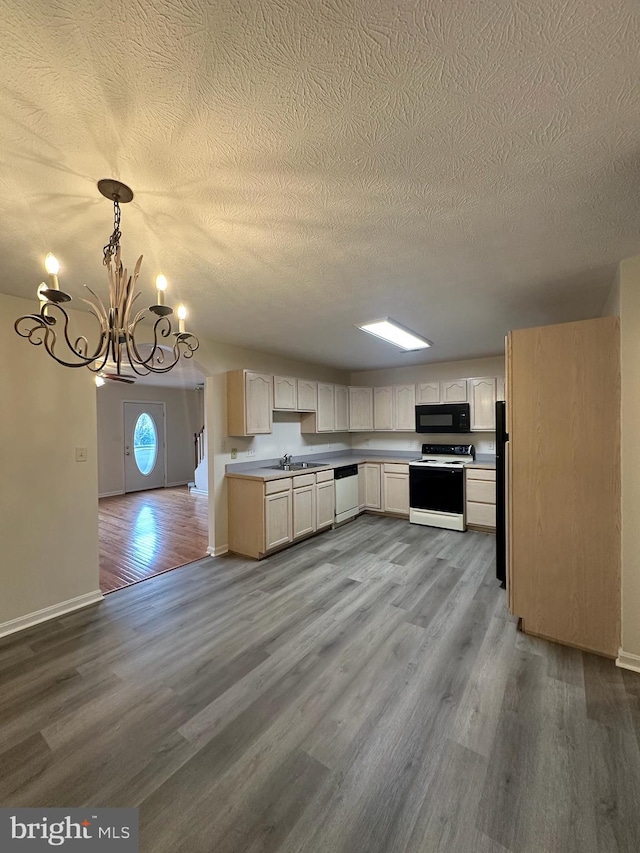 kitchen featuring range with electric cooktop, wood finished floors, white dishwasher, black microwave, and a sink