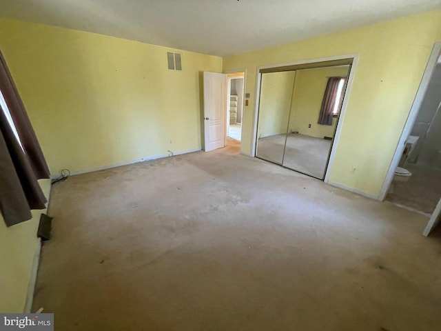 unfurnished bedroom with a closet and visible vents