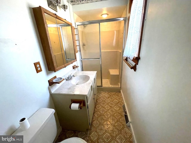 bathroom featuring baseboards, toilet, a stall shower, and vanity