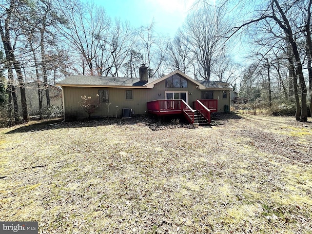 rear view of house featuring central AC unit, a deck, and a chimney