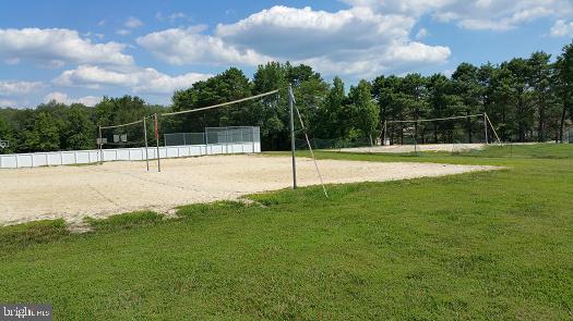 view of community with volleyball court and a yard