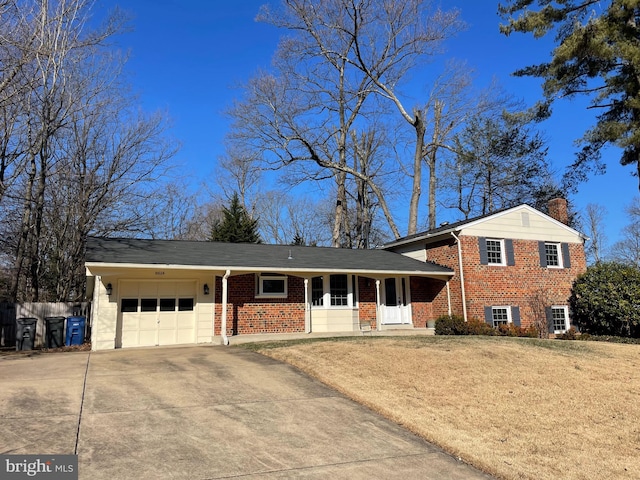 split level home with brick siding, a chimney, a porch, a garage, and driveway