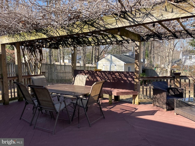 view of patio / terrace featuring a deck, outdoor dining space, and an outdoor structure