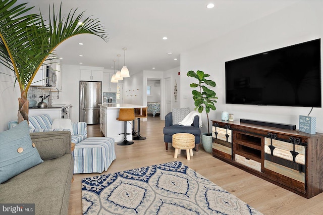 living room with light wood finished floors and recessed lighting