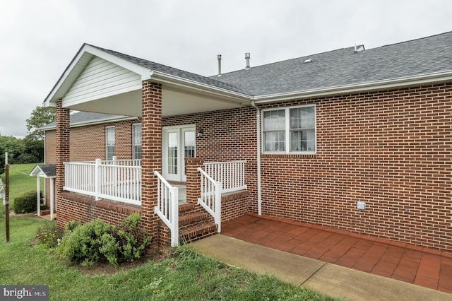 rear view of property with roof with shingles and brick siding