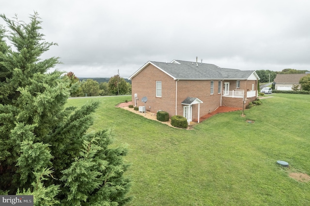 view of home's exterior featuring brick siding and a yard