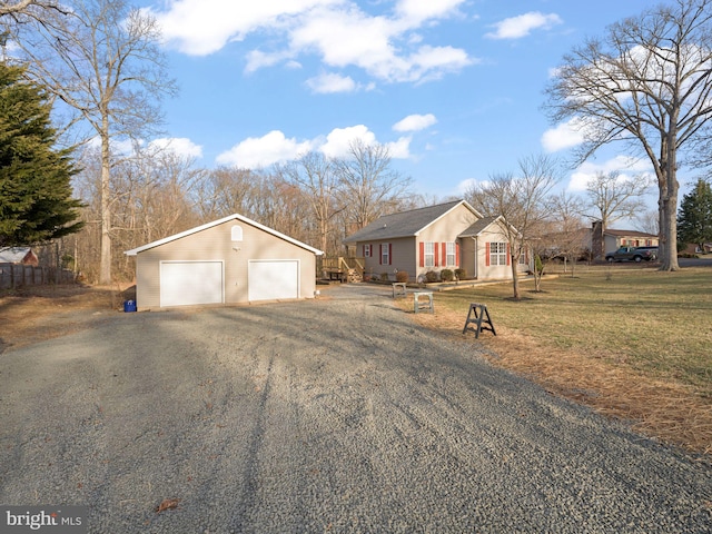 view of front of property featuring a garage, a front yard, and an outdoor structure