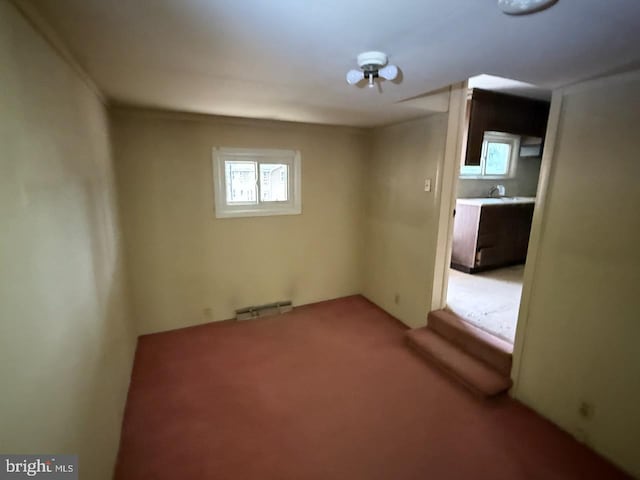 empty room with a sink, visible vents, and light colored carpet