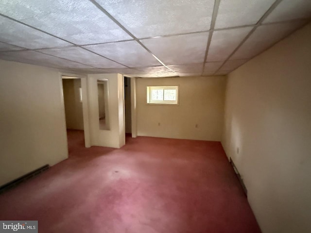 basement featuring a drop ceiling and carpet