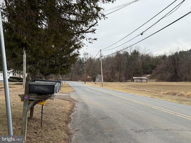 view of road featuring traffic signs and a view of trees